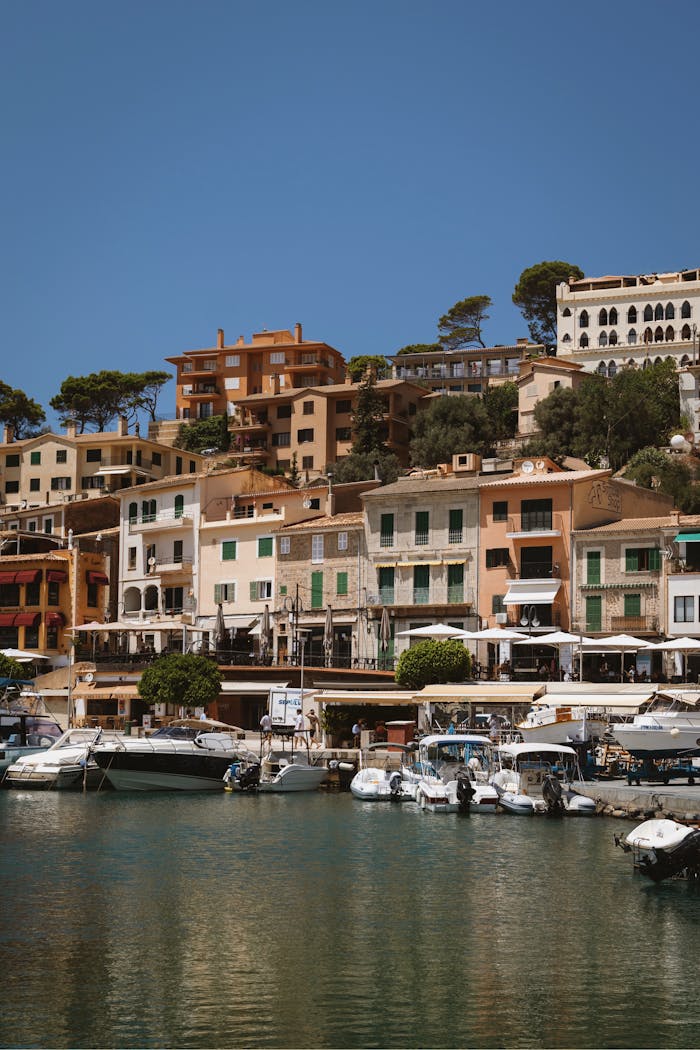 A picturesque harbor in Port de Sóller, Spain, showcasing colorful buildings and serene water